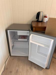 an empty refrigerator with its door open in a room at Halden Motell in Halden