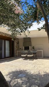 a patio with a table and a bench in front of a building at aganta apartments in Olympiada