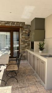 a kitchen with a table and chairs and a sink at aganta apartments in Olympiada +8 photos