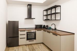 a kitchen with white cabinets and a stainless steel refrigerator at Corte EDN7 in Sannicandro di Bari