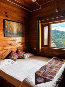 a bed in a wooden room with a window at The Yak House in Chakrāta