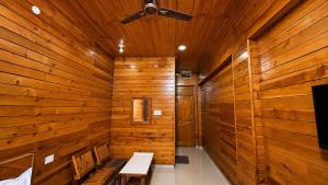 a wooden room with benches and a ceiling fan at The Yak House in Chakrāta