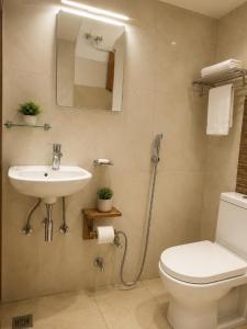 a bathroom with a sink and a toilet and a mirror at The Yak House in Chakrāta