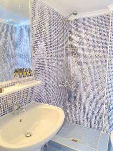 a blue tiled bathroom with a sink and a shower at Ioli Beach in Skala Fourkas +13 photos