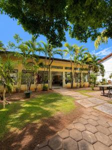 an exterior view of a building with palm trees at Emburi Hotel in Piratininga
