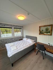 a bedroom with a bed and a desk and a table at Halden Motell in Halden
