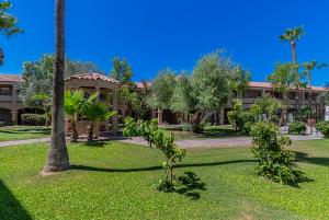 a resort with palm trees and a building at La Fuente Inn & Suites in Yuma
