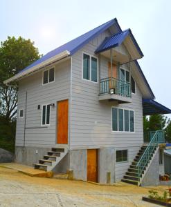 Kampong Kundassan的住宿－T天堂度假屋，一座带橙色门和蓝色屋顶的房子