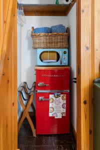 a microwave sitting on top of a red refrigerator at Peaceful Cabin in Idyllwild +36 photos