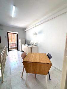 a kitchen with a wooden table in a room at Casa Nica in Naro +5 photos
