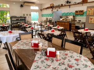 a dining room with tables and chairs in a restaurant at Emburi Hotel in Piratininga +22 photos
