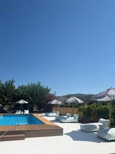 a swimming pool with lounge chairs and umbrellas at The Beach House in Vasilika