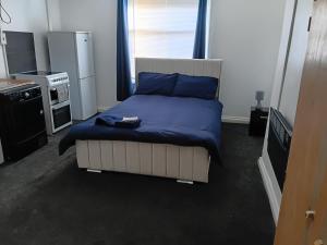 a bedroom with a bed with a blue comforter at Studio Sleeps 2 with Parking in Oldbury