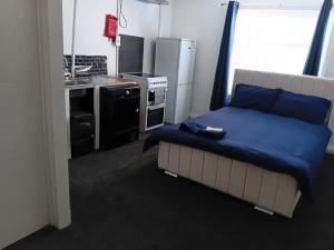 a bedroom with a bed and a kitchen with a sink at Studio Sleeps 2 with Parking in Oldbury