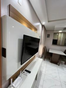 a living room with a large flat screen tv on a wall at 01 Conforto e estilo-piscina e garagem inclusa in São Leopoldo