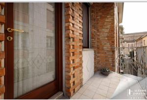 a door to a brick building with a balcony at Residenza San Nicolò in Treviso