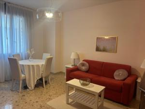 a living room with a red couch and a table at Residenza San Nicolò in Treviso