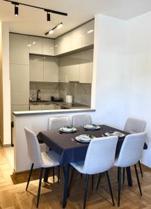 a dining room with a table and chairs and a kitchen at apartment Danijela in Radanovići