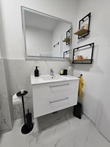 a white bathroom with a sink and a mirror at Sunny Premium in Cristian +15 photos
