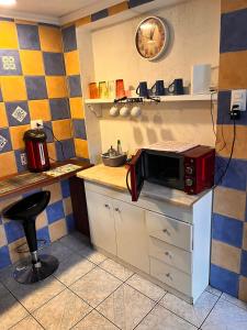 a kitchen with a microwave on top of a counter at Hostal La Casa del Puente in Santiago