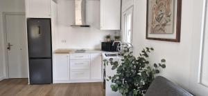 a kitchen with white cabinets and a black refrigerator at Espectaculares Aptos Castillo de Bellver in Camas