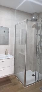 a glass shower in a bathroom with a sink at Espectaculares Aptos Castillo de Bellver in Camas +8 photos