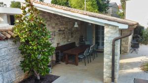 a patio with a wooden table and a brick wall at Heritage Villa Cranzetti in Svetvinčenat +24 photos