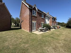 a brick house with a picnic table in the yard at Anchors Away at The Bay Filey, sleeps 7, 2 dogs welcome for free too in Filey