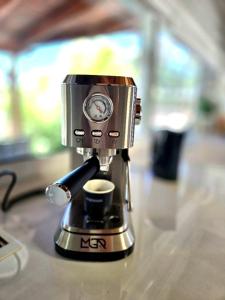 a coffee maker with a cup on a counter at Ktima Voulme in Kavála