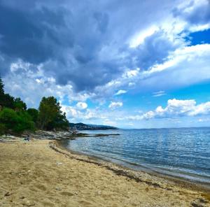 a beach with a cloudy sky and the water at Ktima Voulme in Kavála