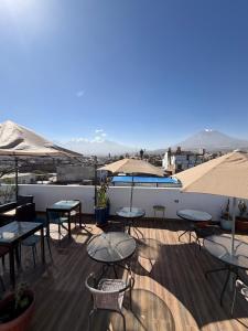 a rooftop patio with tables and umbrellas and a pool at Chikan Hoteles in Arequipa