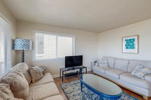 a living room with a couch and a tv at Blue Door Retreat in Cayucos