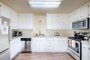 a white kitchen with white cabinets and a sink at Blue Door Retreat in Cayucos +46 photos