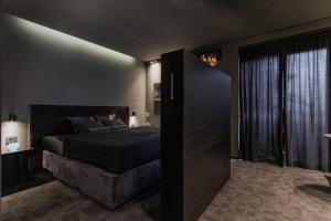 a bedroom with a large bed and a large window at Hedonist SPA in Jagodina