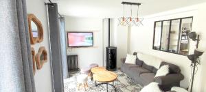 a living room with a couch and a tv at Chalet les Marmottons in Cauterets +5 photos