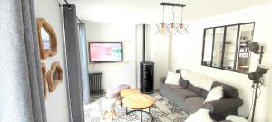 a living room with a couch and a tv at Chalet les Marmottons in Cauterets