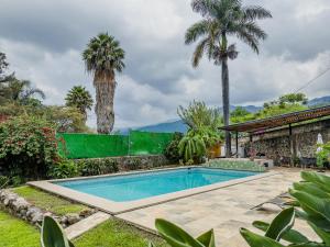 a swimming pool in a yard with palm trees at Refugio del Colibrí in Tepoztlán +118 photos