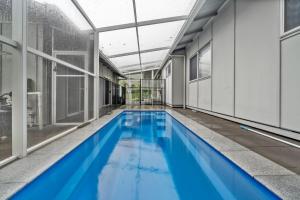 an indoor swimming pool with blue water in a building at Bella on Boreen by Discover Stradbroke in Point Lookout