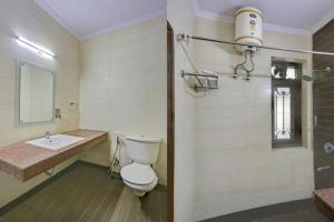 a bathroom with a toilet and a sink at Hotel Rastro Palace in New Delhi