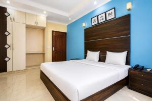 a bedroom with a large bed and a blue wall at Hotel Rastro Palace in New Delhi
