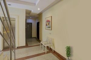 a hallway with two chairs and a stair case at Hotel Rastro Palace in New Delhi