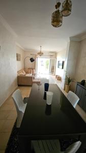 a living room with a black table and white chairs at Villa lux AP2 in Saïdia