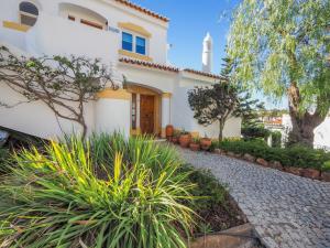 a large white house with a cobblestone driveway at Casa Trajlon in Praia do Carvoeiro