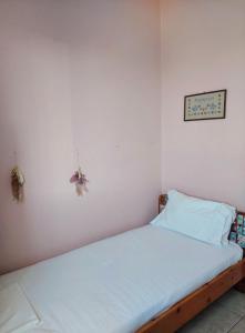 a bed in a room with a white wall at Dora's Sweet Home in Mytikas