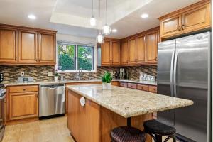 a kitchen with wooden cabinets and stainless steel appliances at Garden Escape in Santa Barbara