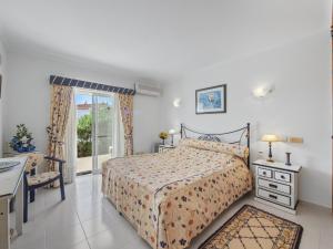 a bedroom with a bed and a table and a window at Casa Trajlon in Praia do Carvoeiro