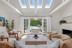 a living room with a vaulted ceiling with a skylight at Hedgerow Jewel Box in Santa Barbara
