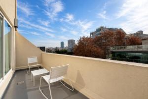 two chairs on a balcony with a view of a city at Purobaires Hotel Boutique in Buenos Aires