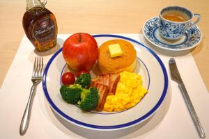 a plate of breakfast food with an apple and eggs at Shibuonsen YAMAICHIYA in Yamanouchi