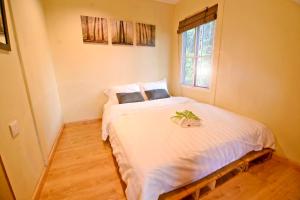 Schlafzimmer mit einem großen weißen Bett und einem Fenster in der Unterkunft T Paradise in Kampong Kundassan